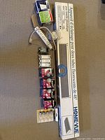 Photo showing the HomeVue 48-inch double fluorescent fixture box, power bar, Decora switches, and small packaged bulbs