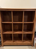Front view of brown oak veneer bookcase showing 3x3 grid compartments