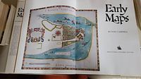 Open book showing a detailed historic map illustration and the title page with the author's name and publisher.