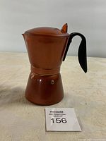 Full shot of the metal stovetop espresso maker showing entire body and handle.