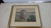 Framed block print showing Fort Henry East Ditch Tower by water with surrounding vegetation and distant horizon.