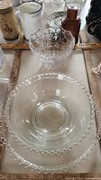 Overview photo showing Waterford crystal tulip etched bowl centered with Imperial Glass bubble edge bowl and matching plate beneath and around it. Measuring rulers placed to confirm size.