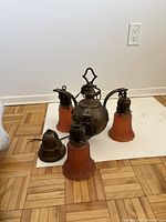 Antique hanging light with metal spherical center and three amber glass shades resting on white surface