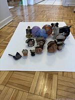 Photo of all items showing a ceramic dog, glass spheres, and multiple ceramic character miniatures arranged on white background.