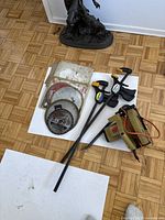 Overview of Black & Decker circular saw, three saw blades and two quick grip clamps on floor.