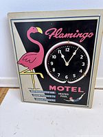 Front view of metal Flamingo Motel sign with integrated neon-accented clock