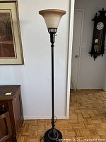 Full view of the floor lamp standing upright in a room, showing its height and proportion with surrounding furniture.
