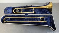 Full view of King Cleveland 605 trombone inside blue plush-lined case showing bell and slide sections.