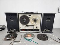 Full view of SONY TC-252 tape recorder with two speakers and three reel tapes spread out in front.