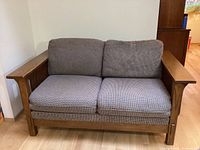 Front view of mission style loveseat showing two seat cushions and two back cushions with wooden armrests and frame.