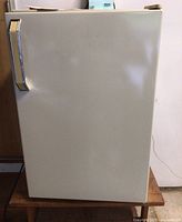 Front view of Montgomery Ward beige mini freezer with chrome handle.