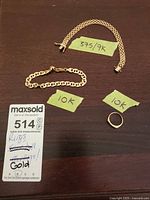 Overview of all three gold items on table with auction tag visible