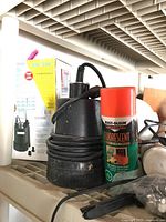 Burcam submersible pump, Rust-Oleum fluorescent spray paint can, and its box showing product info
