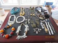 Full lot arranged on a table showing various chunky necklaces, bracelets, watches, and earrings in multiple colors and materials