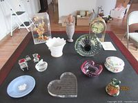 Wide view showing all items on a coffee table including Linden clock, art glass vase, paperweight, vases, trinket box, ashtrays, and glass heart.