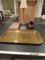 The complete lot displayed showing brass tray in front, lamp candle with fabric shade behind, small glass dish, wooden clog, and small brass hexagonal decor piece to the right.