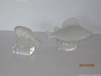 Both Lalique crystal figurines displayed together on white background showing size and detail.