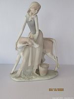 Frontal view of the vintage Lladro figurine showing the girl and calf with matte finish and soft color tones.