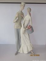 Front view of the vintage Lladro figurine featuring a man and woman in elegant attire in a flirtatious pose.