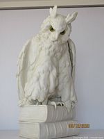 Front view of bisque owl sculpture perched on two stacked books, showing overall appearance and height.