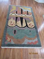 Full view of the Tufenkian Tibetan carpet on hardwood floor showing abstract multicolor design.
