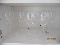 Eleven clear crystal wine glasses arranged in two rows, showing overall quantity and uniform design.