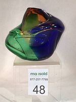 Front view of the cobalt blue, amber, and green blown glass vase, showing organic layered form.