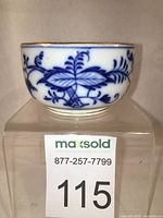 Gold gilded small Meissen dish with hand painted Blue Onion pattern in cobalt blue on white bone china, shown front and side view.