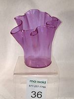 Front view of rose iridescent handkerchief glass vase with multiple ruffled edges on rim.