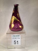 Front view of the purple-pinkish hand blown glass vase with irregularly applied gold leaf decoration on the exterior.