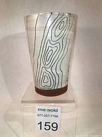 Front view of the pottery tumbler showcasing carved and painted topography lines on cream slip with visible red clay base and 'TOPO POTS' stamped signature.