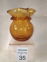 Front view of vintage Pilgrim amber crackle glass vase on stand with lot number sticker visible.