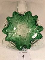 Top-down view of emerald green Murano glass bowl with sculptural, irregular wavy edge and crackle bubble pattern inside.
