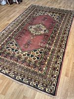 Full view of rug laid on floor showing overall pattern, colors and condition