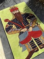 Full view of rug laid flat showing entire Rostam figure on light green field