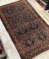 Full view of rug laid flat on wood floor showing overall design, coloration and shape