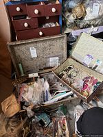 Open vintage suitcase with various jewelry‐making supplies and tools inside