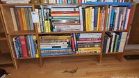 Photo of bookshelf featuring a collection of assorted books on multiple subjects including travel, home repair, history, and culture.