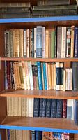 Books on wooden shelves, showing a variety of titles related to Jewish faith, philosophy, and religion.