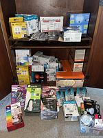 Full view of light bulbs assortment arranged on floor and shelves, showing variety of brands and packaging sizes