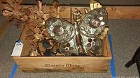 Box containing assorted metal wall art pieces including large butterfly and leaf motifs.