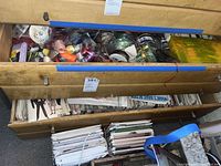 Wooden chest with upper drawer full of ribbon spools and lower drawers with sewing pattern envelopes