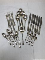 All utensils laid out, showing knives, forks, dessert spoons, teaspoons, coffee spoons