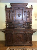 Full front view of the antique wooden cabinet showing upper compartments, carved details, and side boards extended.