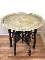 Brass tabletop assembled on wooden folding stand