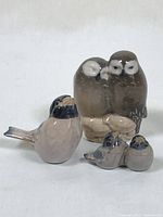 Three porcelain figurines including the Royal Copenhagen owl duo and two Dissing Keramik bird figurines.