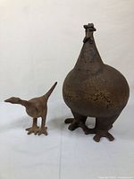 Wide shot displaying both pottery chickens on white backdrop, showing size and form difference