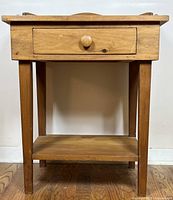 Full front view of pine side table showing drawer and lower shelf