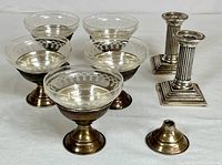 Front view showing four etched glass sherbet cups with sterling bases alongside two fluted column sterling candlestick holders and one detached base.