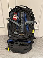 Front view of the Asolo Navigator 80 backpack showing the black and blue fabric with grey straps and Canadian flag patch.